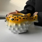 Creative pufferfish tiki mug for cocktails with vibrant hand-painted details on a wooden table