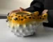 Creative pufferfish tiki mug for cocktails with vibrant hand-painted details on a wooden table