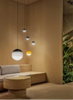 Gray glass pendant lamp in a hallway with a white wall and wooden floor, adding elegance.