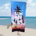 Vibrant summer travel beach towel with palm tree print, laid on sandy shore