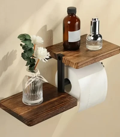 Wooden toilet paper holder mounted on a white bathroom wall with a roll of tissue hanging down.