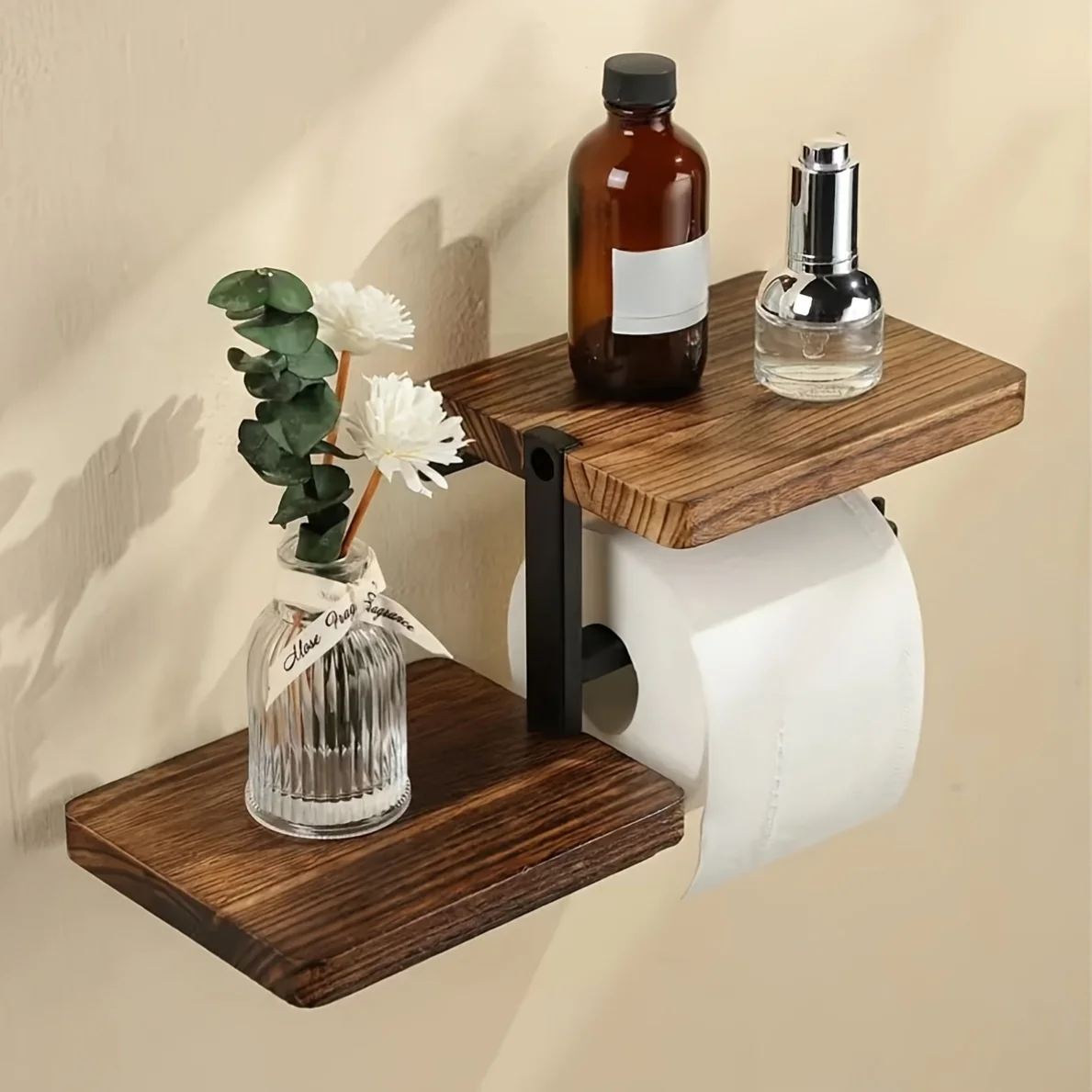 Wooden toilet paper holder mounted on a white bathroom wall with a roll of tissue hanging down.