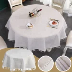 Round linen tablecloth with tassels on a dining table
