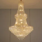 Modern crystal chandelier for dining room hanging over a wooden table with warm glow