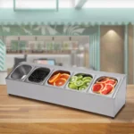 Stainless steel spice rack with 5 pans and lids on kitchen countertop
