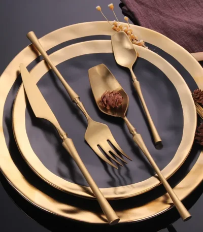 Matte black gold flatware set arranged on a table, showcasing elegant cutlery