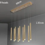 Copper metal pendant lamp with exposed bulb in an industrial style kitchen.