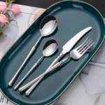 Matte gold flatware set with antique finish arranged on a wooden table