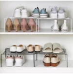 Adjustable dish drying rack with multiple tiers holding plates, bowls, and spice jars on a kitchen counter