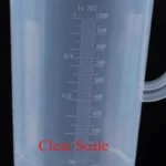 Transparent plastic lab beaker with measurement scale on kitchen counter
