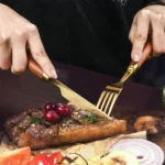 4-piece stainless steel flatware set with sapele wooden handles on a table