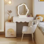 Modern makeup vanity desk with mirror and stool in a bedroom setting, showcasing ample storage and elegant design