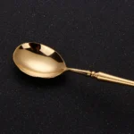 Matte gold flatware set with antique finish arranged on a wooden table