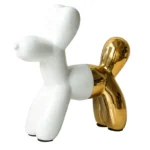 Side view of the gold ceramic dog statue on a modern office desk with a laptop.