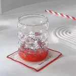 Set of glass cups with straws on a wooden table, filled with iced tea and lemon