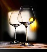 Elegant crystal wine glass set on a wooden table with soft lighting