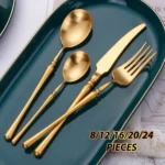 Matte gold flatware set with antique finish arranged on a wooden table