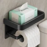 Close-up of aluminum toilet paper holder, highlighting brushed metal texture and roll edge.