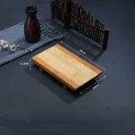 Bamboo sushi serving tray with assorted sushi rolls and sashimi on a wooden table