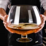 Large wine glass filled with red wine on a wooden table