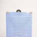 Non slip bath mat with suction cups in a white bathroom