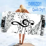 Vibrant guitar beach towel with colorful musical notes pattern on a sandy beach