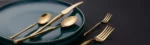 Matte gold flatware set with antique finish arranged on a wooden table