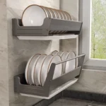 Stainless steel wall mounted dish rack holding plates and bowls in a modern kitchen