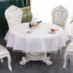 Round linen tablecloth with tassels on a dining table