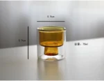 Clear double wall insulated glass mug with espresso coffee on wooden table