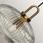 Nordic LED hanging light with a smoked glass shade, suspended above a bedside table in a bedroom.