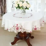 Elegant lace tablecloth with rose gold embroidery on a dining table