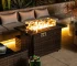 Rectangular propane fire pit table with tile top and wicker base on patio