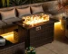 Rectangular propane fire pit table with tile top and wicker base on patio
