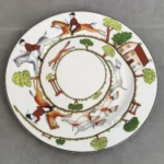 Ceramic dinner plates arranged on a wooden table with cutlery and napkins