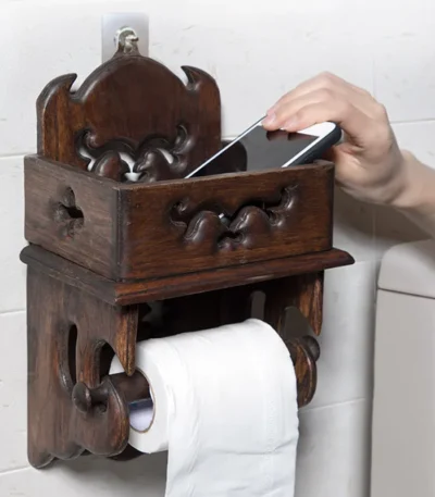 Vintage wood paper towel rack on a bathroom counter, natural grain and brown finish visible.