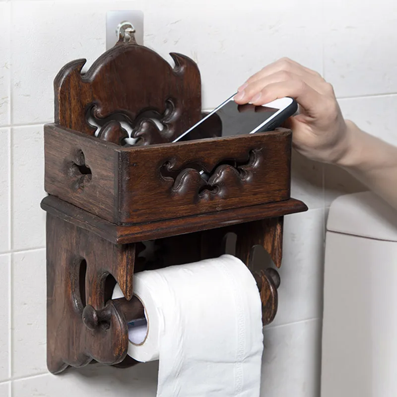 Vintage wood paper towel rack on a bathroom counter, natural grain and brown finish visible.