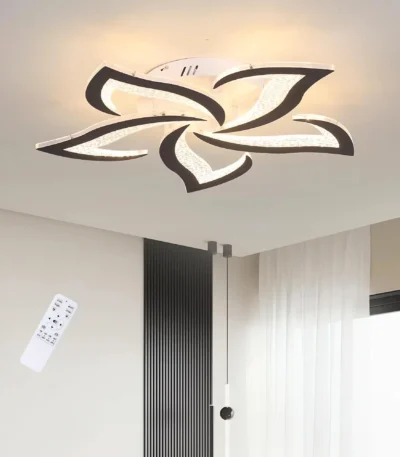 Modern black LED ceiling light in flower design, flush mount, glowing warmly in a cozy living room setting.