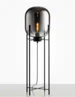 Modern floor lamp with iron frame and glass shade in a cozy living room