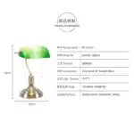 Antique bronze table lamp with green shade on bedside table