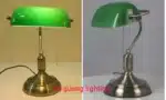Antique bronze table lamp with green shade on bedside table