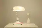 Antique bronze table lamp with green shade on bedside table