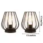 Set of two metal cage table lamps with warm glow on wooden table