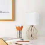 Modern gold table lamp with linen shade on bedside table in bedroom
