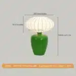 Vintage table lamp with retro ceramic base and silk shade on bedside table in cozy bedroom