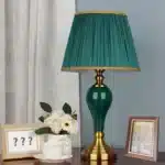 Green ceramic table lamp with European cloth shade in a modern living room setting