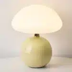 Mushroom table lamp with cream ceramic shade on bedside table