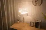 White ghost table lamp with transparent baroque design on a bedside table in a modern bedroom