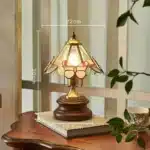 Vintage desk lamp with stained glass butterfly shade casting warm glow on bedside table
