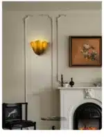 Modern wall sconce with shell-shaped glass and LED light in a minimalist living room